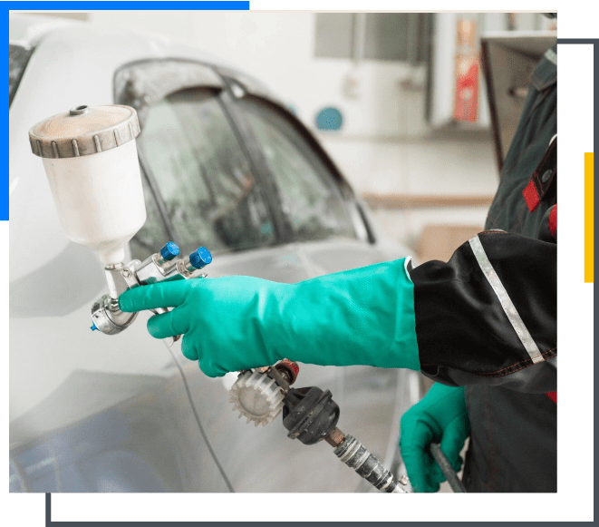 A person in green gloves spraying paint on a car.