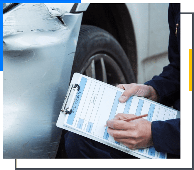 A person holding papers near the tire of a car.