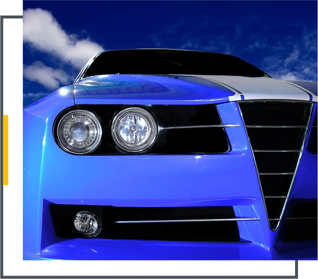 A blue car with chrome grill and headlights.